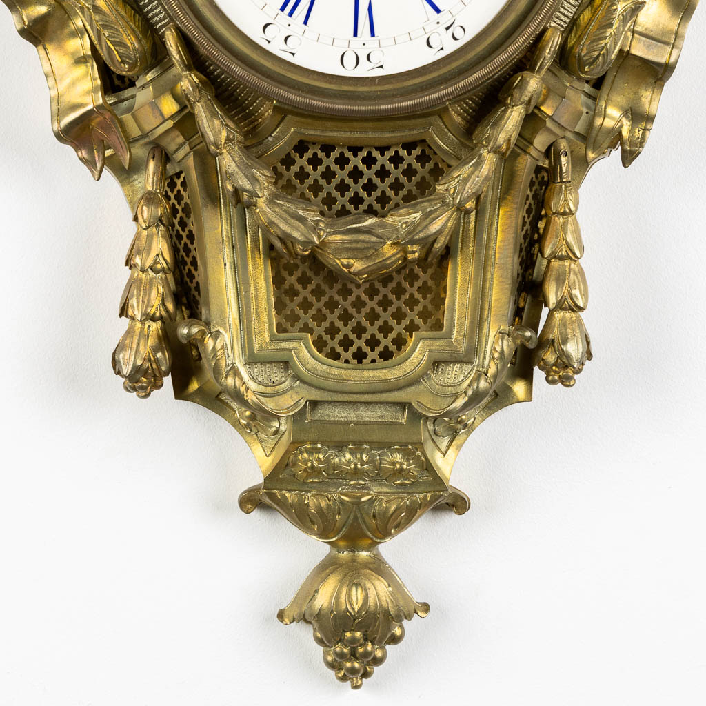 A wall-mounted bronze cartel clock, Louis XVI style. 19th C. (L:12 x W:37 x H:71 cm)