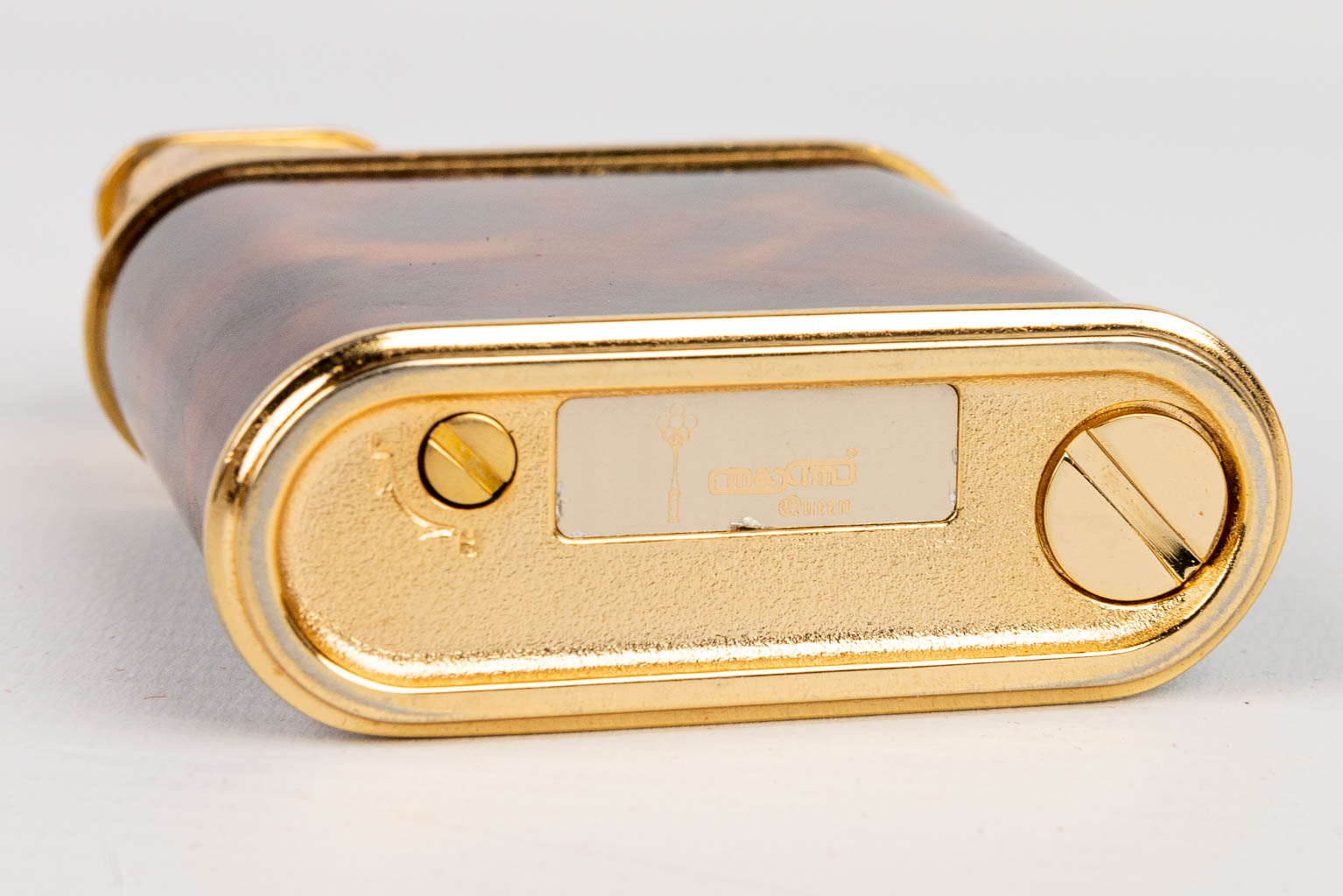 A gold-plated table lighter, decorated with tortoiseshell and marked Maxim. In working condition. (H:7,8cm)