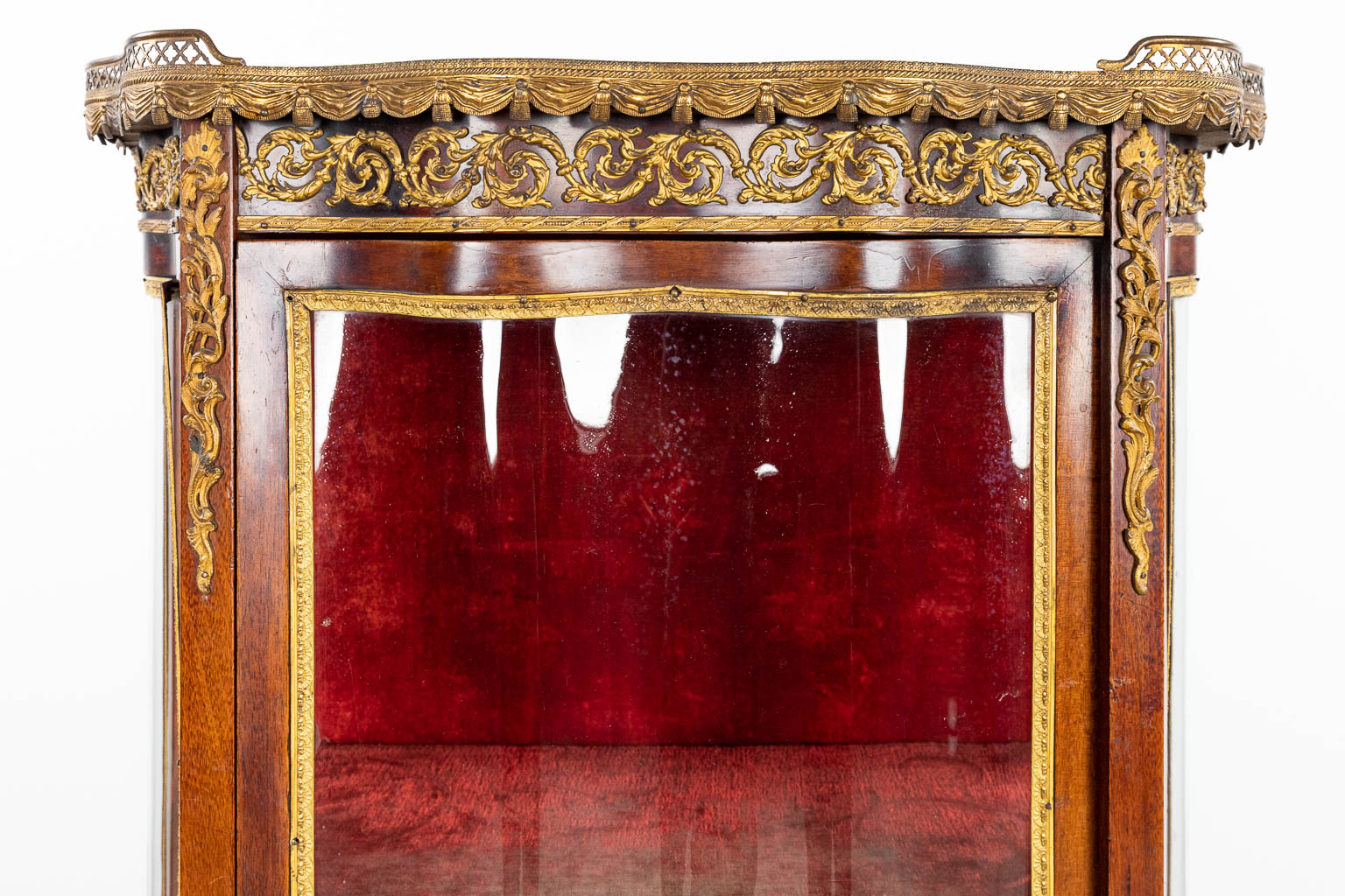 A display cabinet with curved glass, in Louis XVI style. (H:139cm)