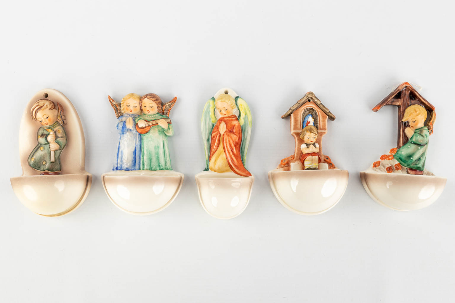 Hummel, a collection of 14 holy water fonts, 4 plates and 3 bells. (H: 13,5 cm)