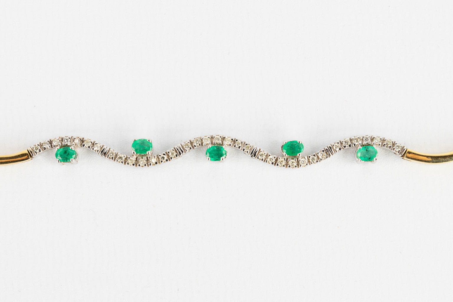 A necklace, 18 karats yellow and white gold, decorated with green, probably, emeralds. 24,67g.