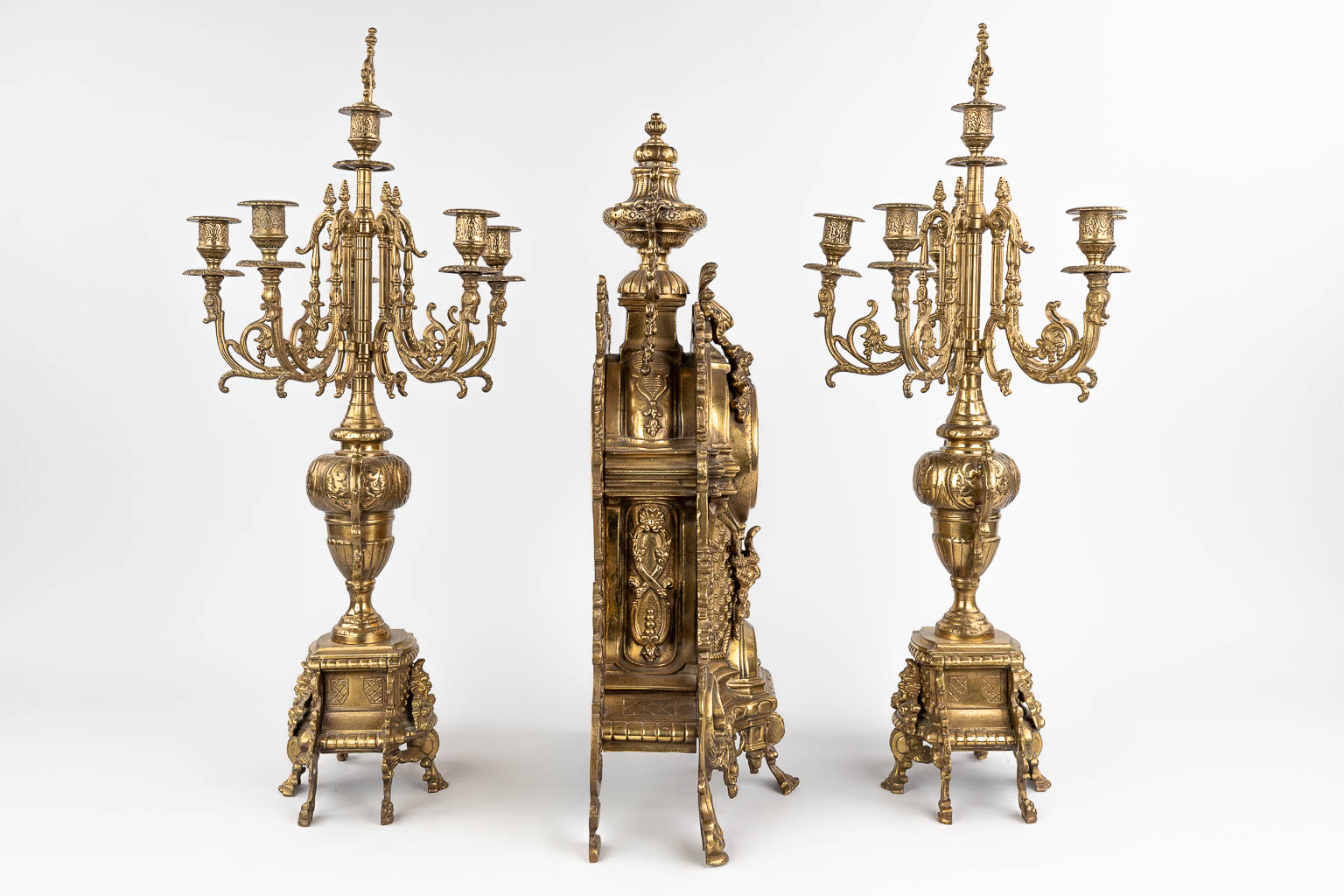 A three-piece mantle garniture consisting of a clock with candelabra, made of bronze. circa 1970. (W: 36 x H: 60 cm)