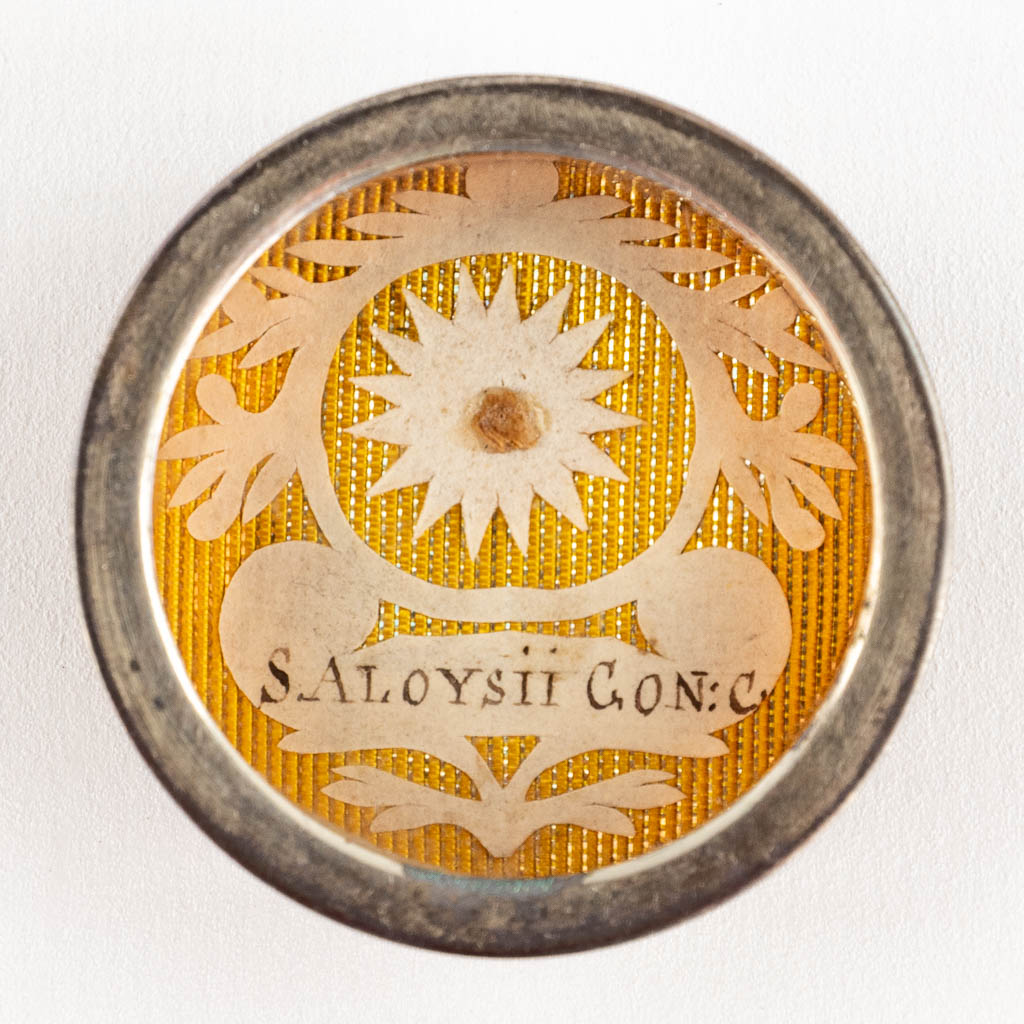 Een verzegelde theca met relikwie en document: Ex Arca Sepulerali Sancti Aloysii Gonzales C. (H:1,2 x D:3,7 cm)