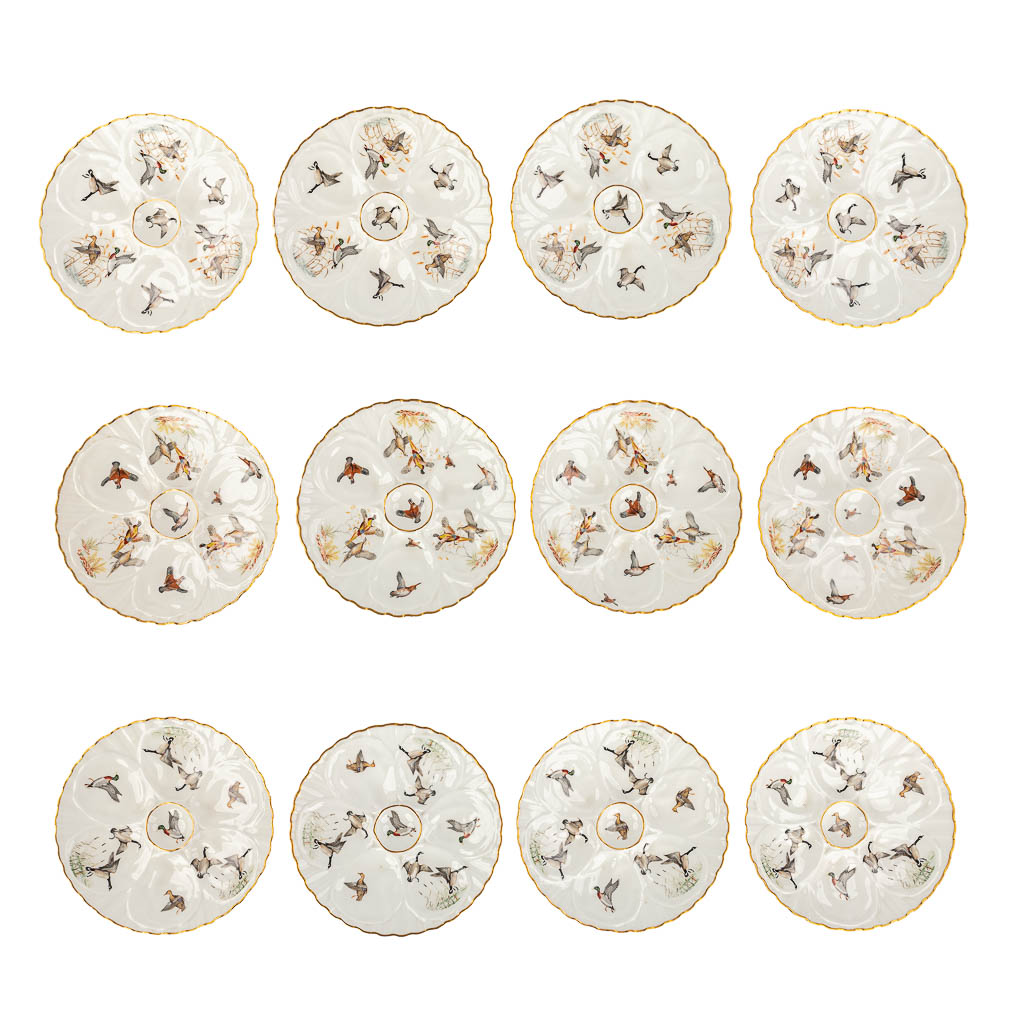  Porcelaine De Paris, France, a collection of 12 oyster plates decorated with birds. 20th C. 
