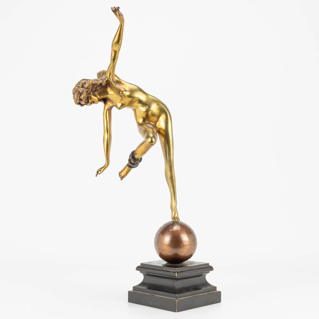 Een figuur 'Danseres met slang' gemaakt uit verguld brons in art deco stijl en gemonteerd op een metalen sokkel