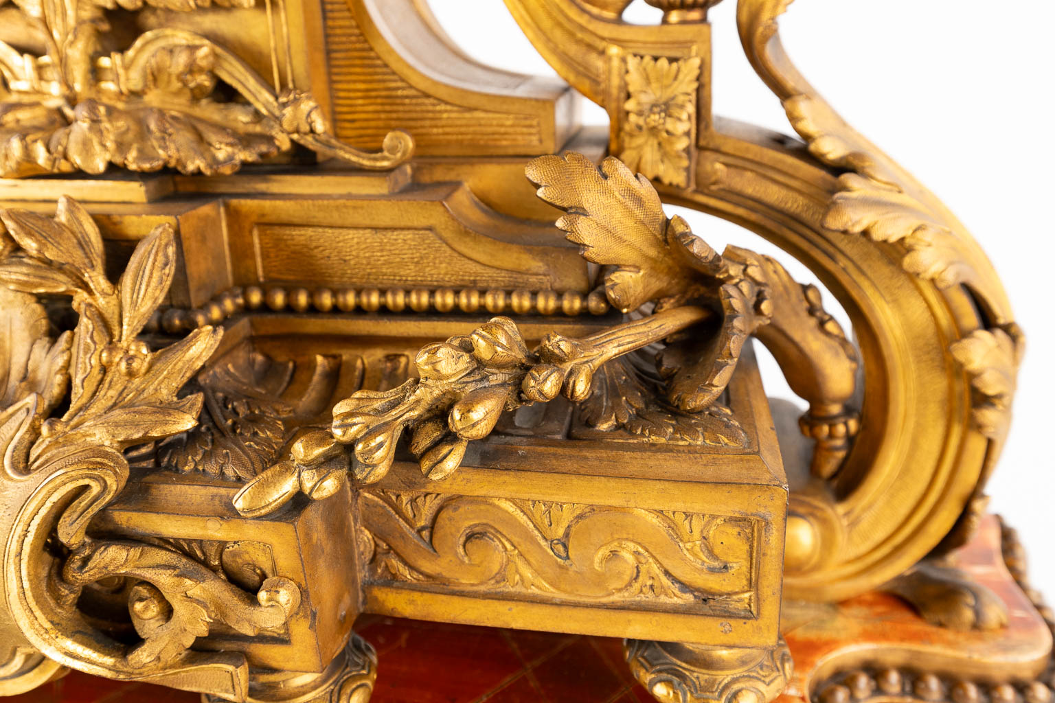 An antique mantle clock, gilt bronze in a Louis XVI style, decorated with ram