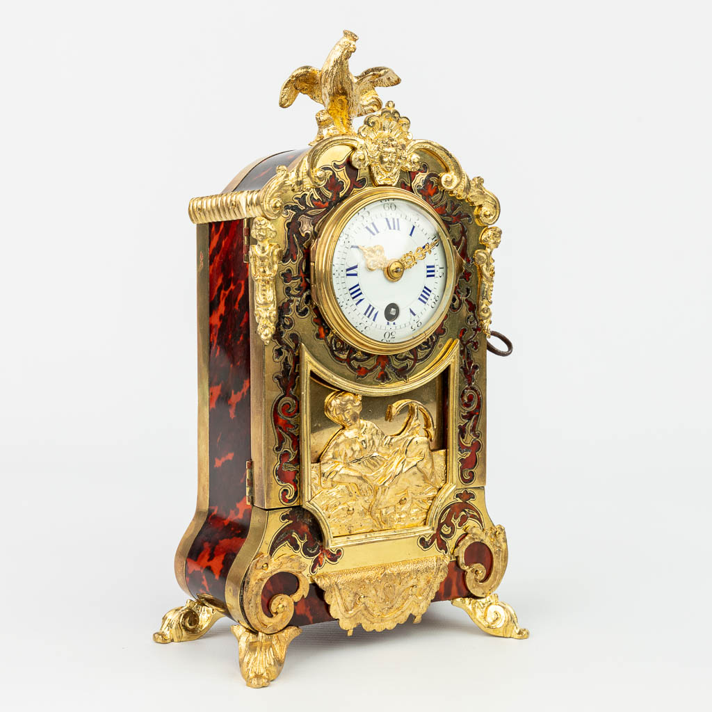 A mantle clock finished with tortoise shell Boulle inlay and mounted with gilt bronze. (H:26cm)