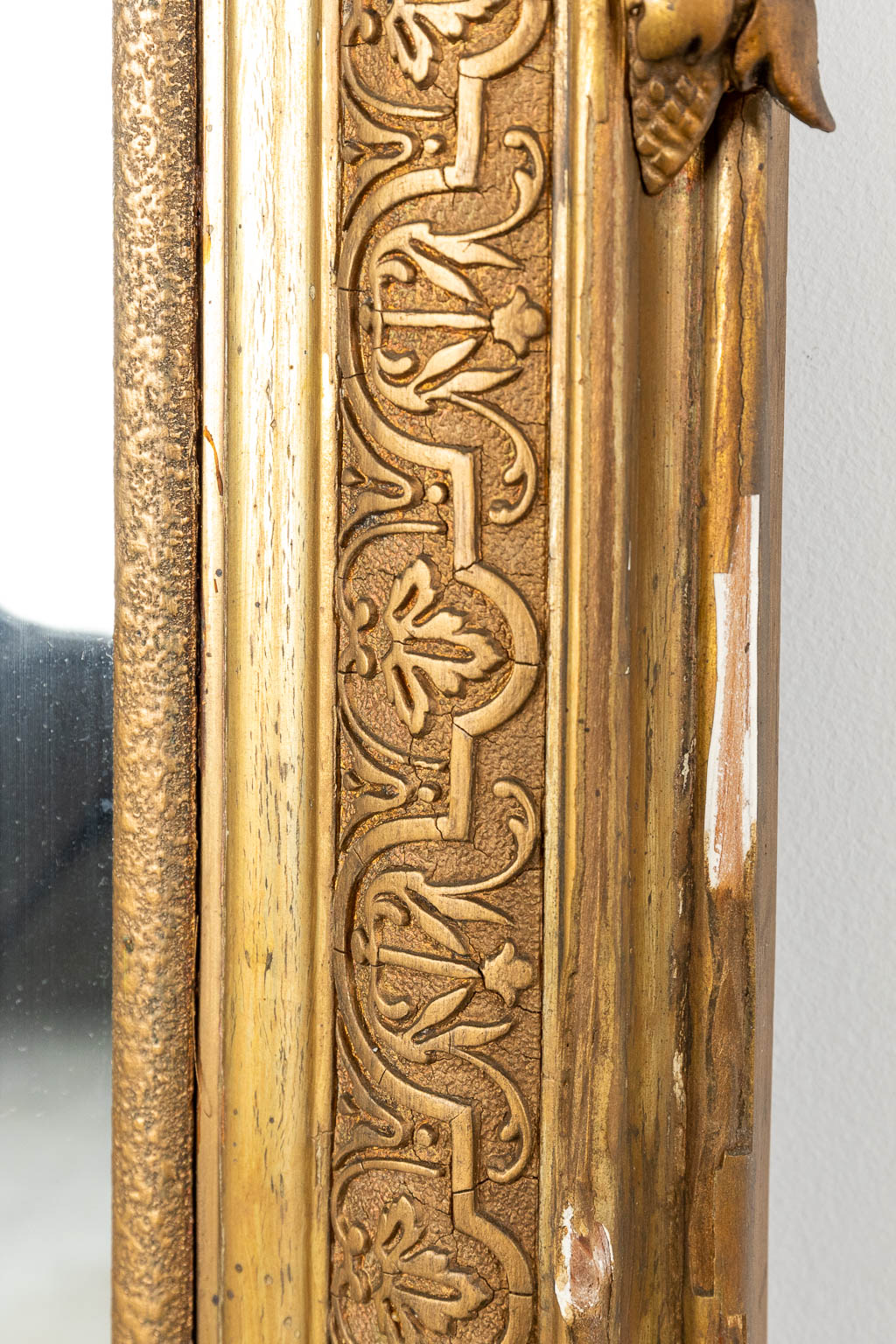 Een spiegel gemaakt uit hout, en afgewerkt met vergulde stucco. (H:148cm)