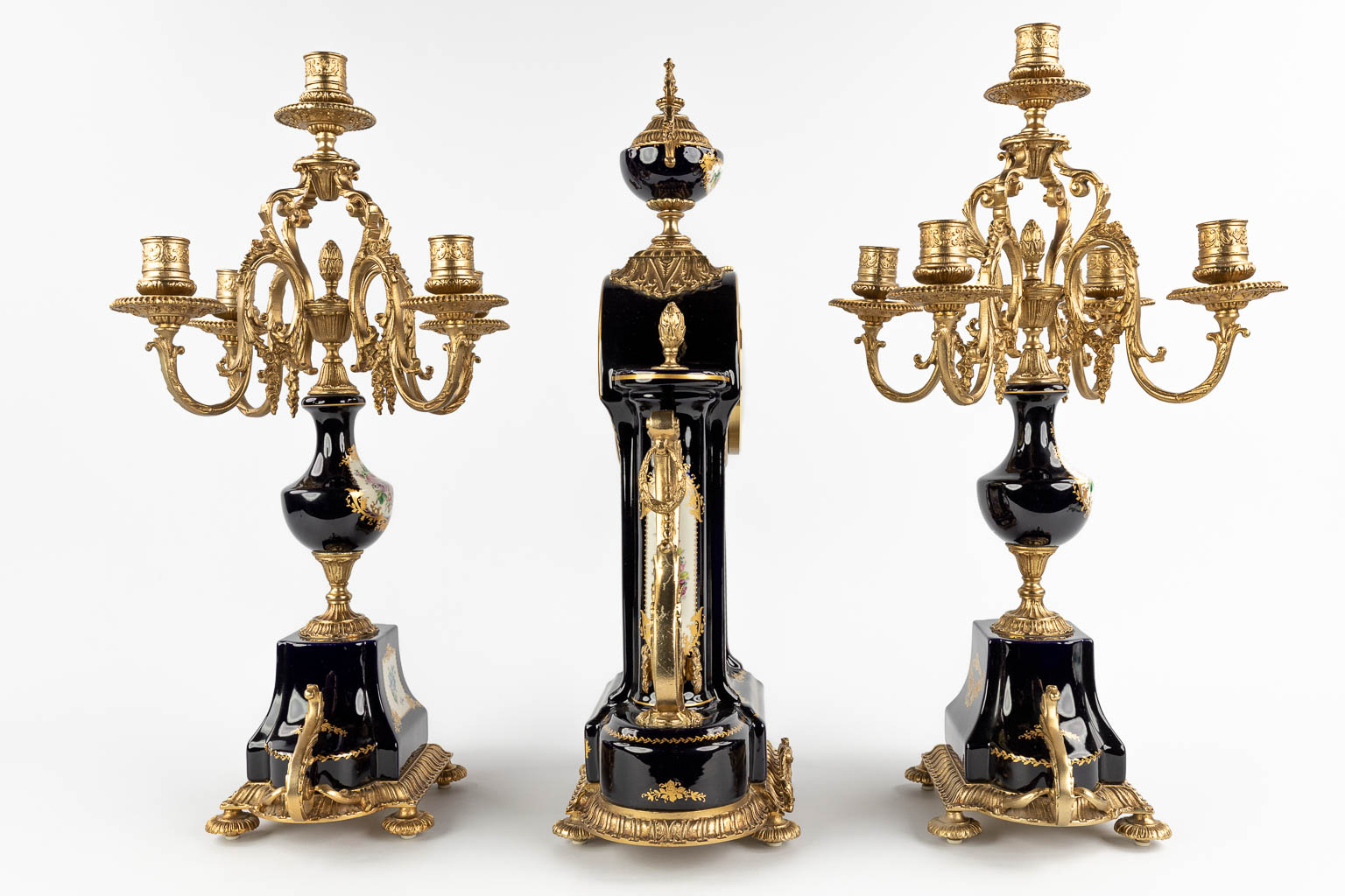 A three-piece mantle garniture clock with candelabra, porcelain mounted with bronze, marked A.C.F. decor de Sèvres (D:17 x W:32