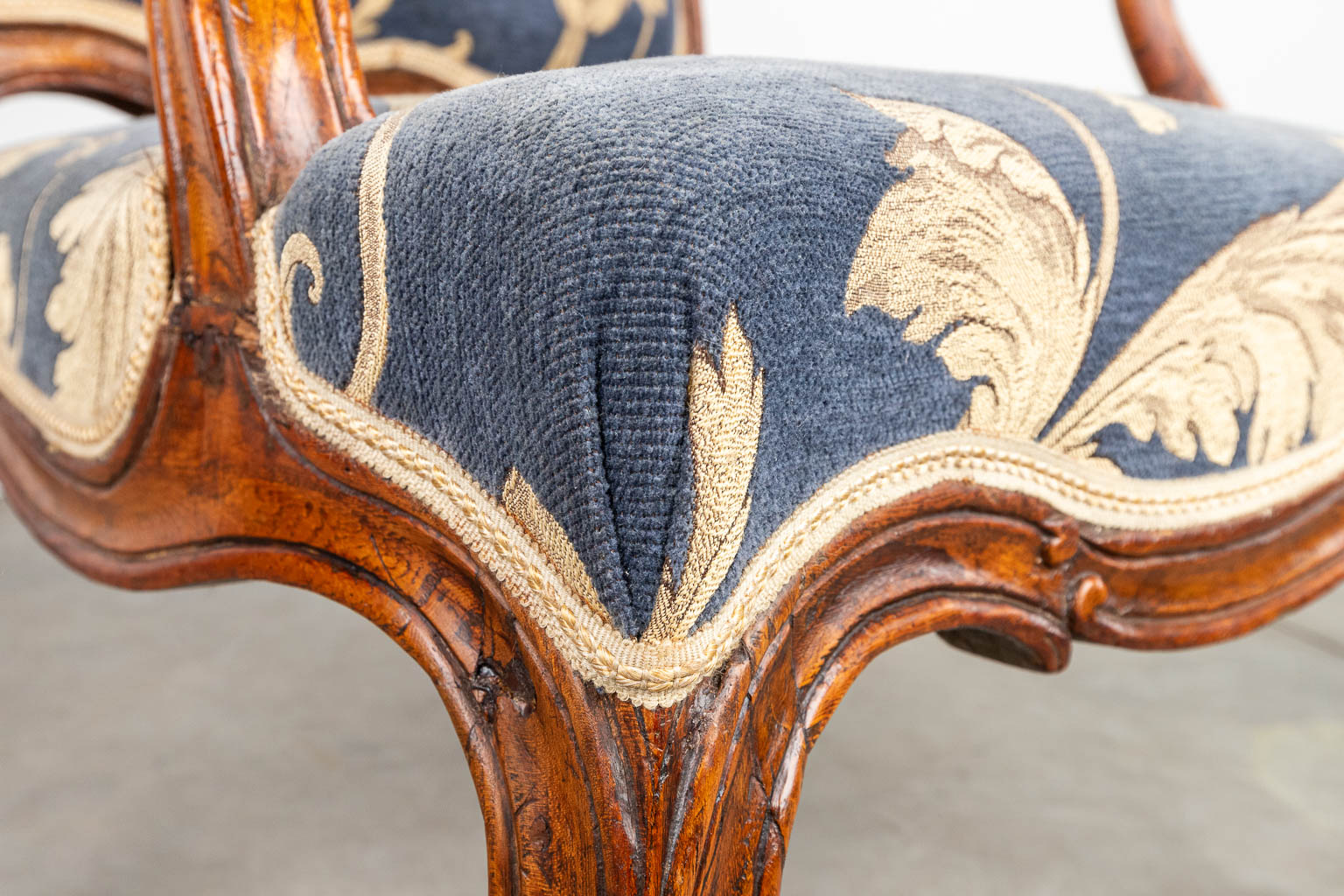 An armchair made in a Louis XV style and upholstered with fabric. Around 1800. (H:96cm)