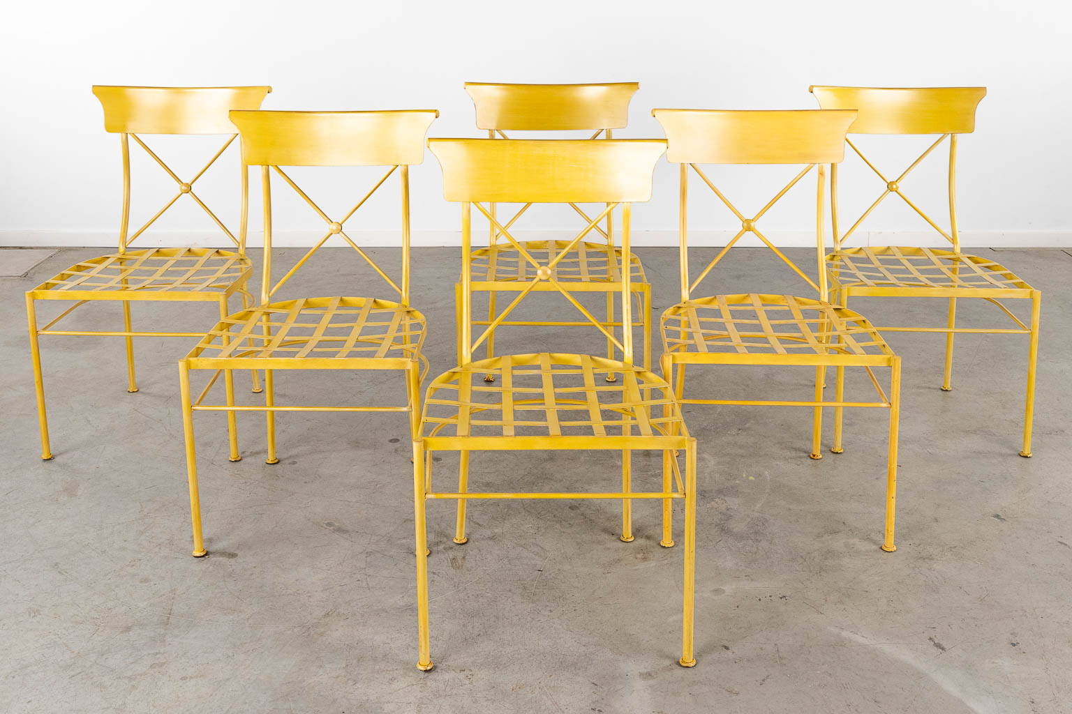 Een ronde tafel met 6 bijhorende stoelen, gepatineerd metaal. 20ste eeuw. (H:77 x D:130 cm)