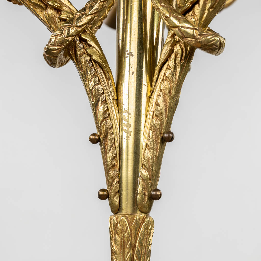 Een luchter, verguld en gepatineerd brons, decor met een putto en glazen rozen lampenkappen. 20ste eeuw. (H:100 x D:66 cm)