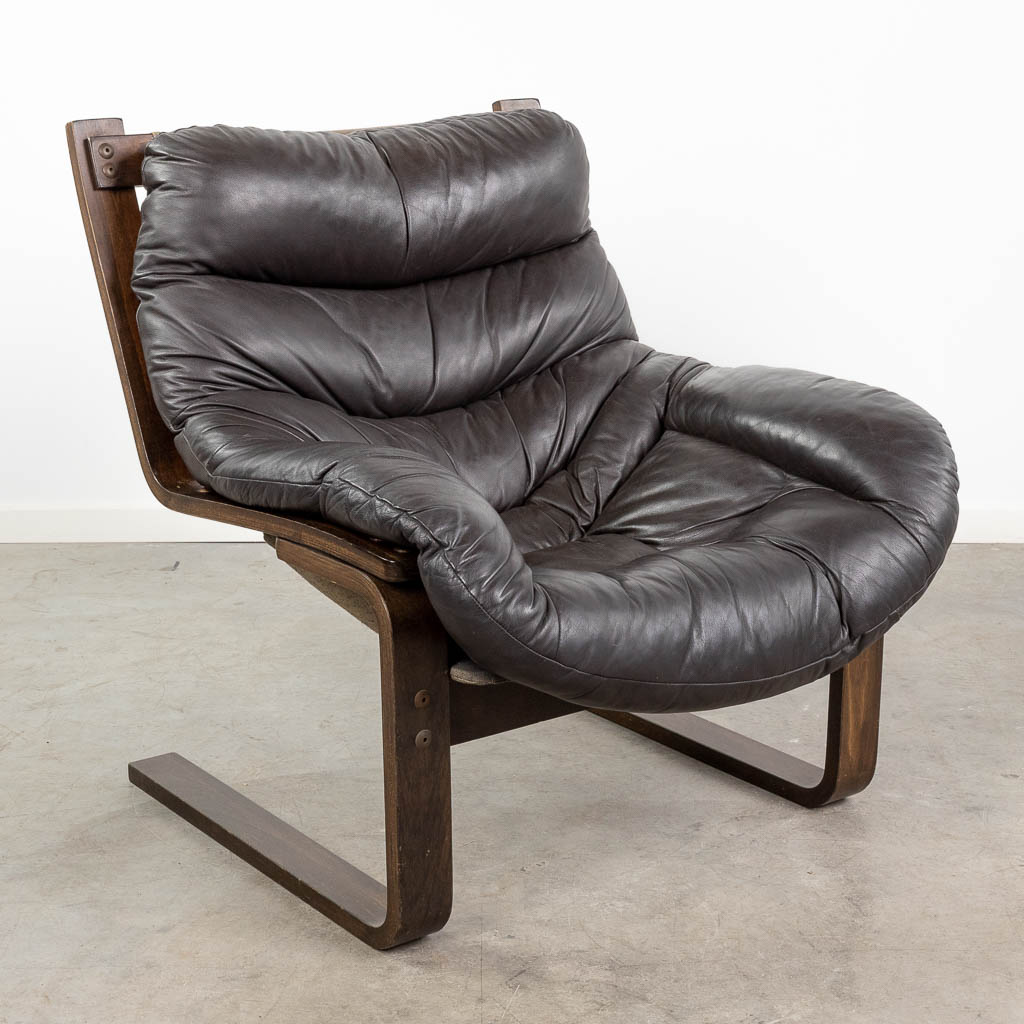  A mid-century cantilevered armchair, made of leather and wood. Probably made in Denmark.  (L:88 x W:72 x H:80 cm)