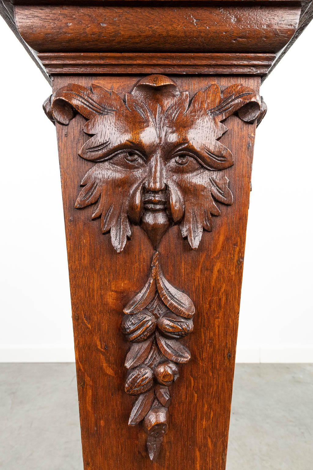 Een piedestal gemaakt uit gesculpteerd hout, en afgewerkt met mythologische figuren. (H:99cm)
