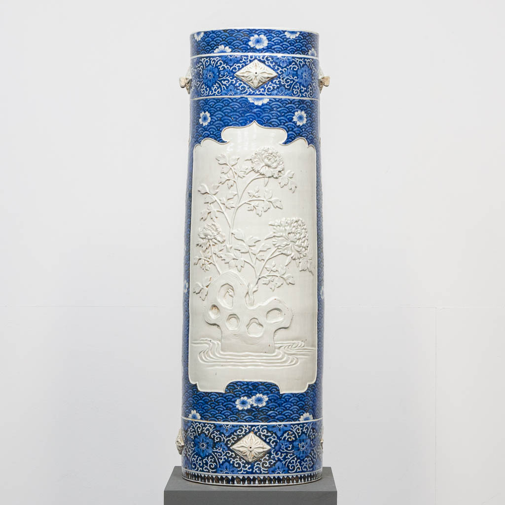 A large blue and white Chinese vase, with white relief decor of peonies