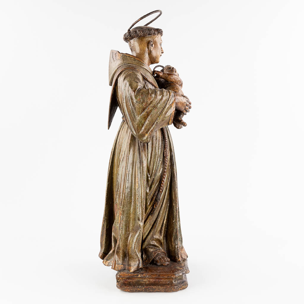 An antique wood-sculptured and polychrome figurine of Saint Anthony with a child. 18th century. (W: 28 x H: 74 cm)