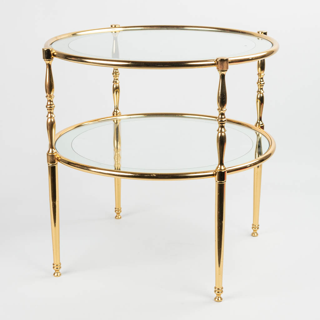 A mid-century coffee table made of brass and glass. The edges of the glass are mirrored. 