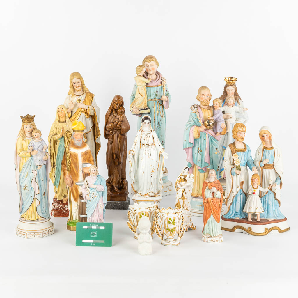 A large collection of 16 coloured bisque statues of holy figurines. (H:44cm)