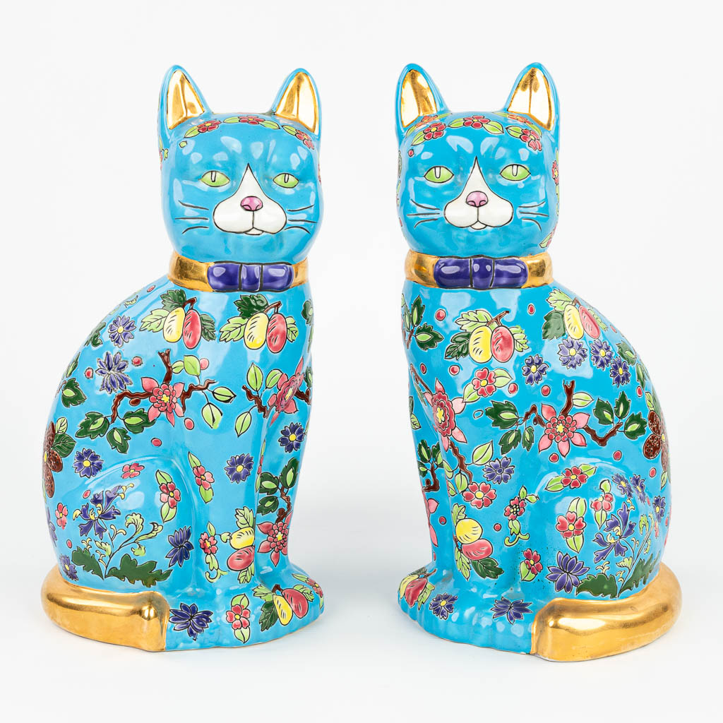  A pair of decorative cats made of glazed faience in the style of 'Emaux de Longwy'.