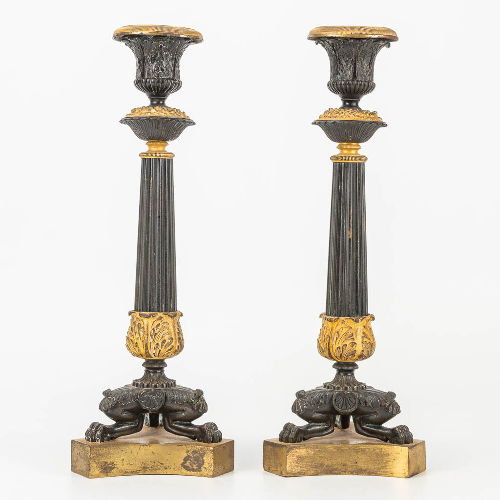 Een paar kandelaars gemaakt uit verguld en gepatineerd brons in empire stijl. 