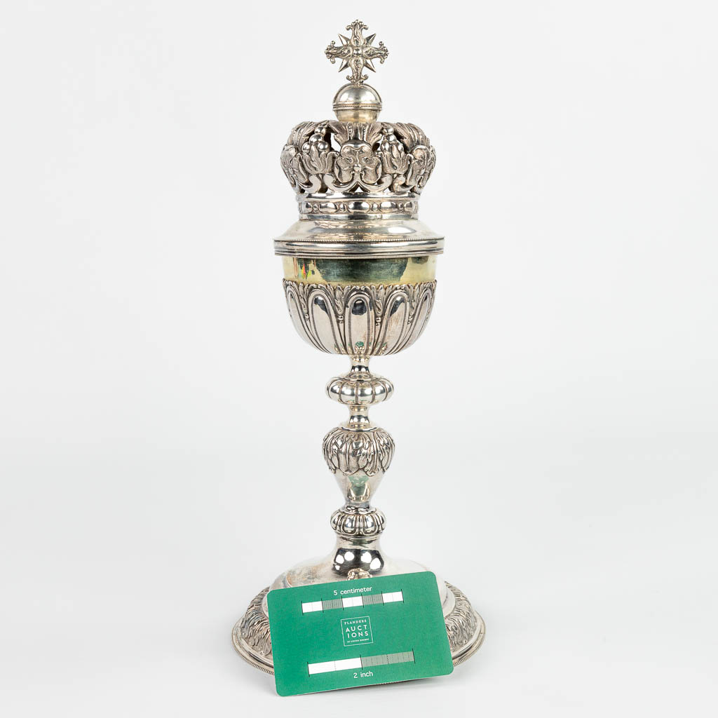 Een ciborie gemaakt uit zilver met opengewerkte kroon. Gemerkt met Dubbele Janus, Tweede gehalte 833/1000. 508g. (H:32cm)