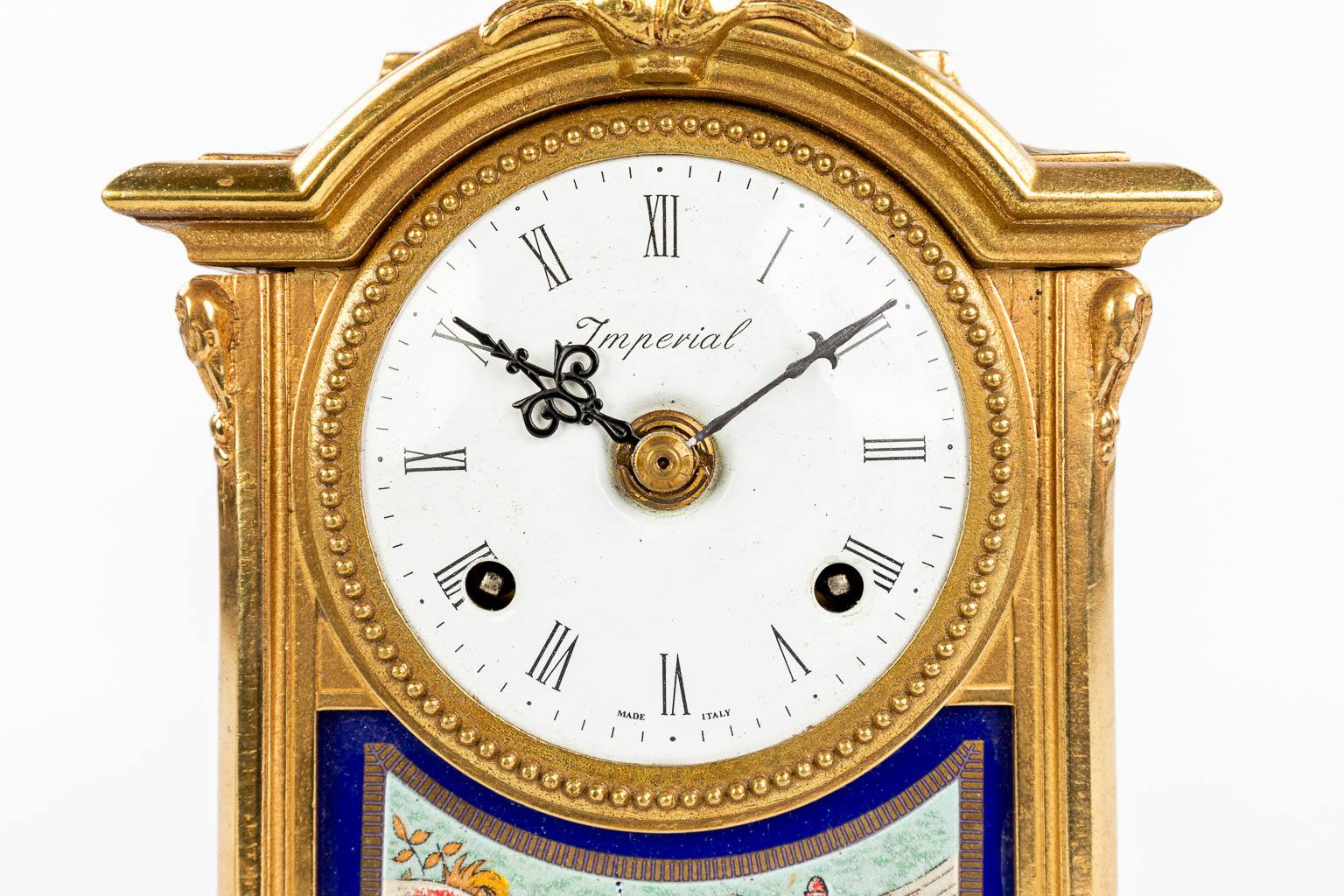 A three-piece mantle garniture clock made of bronze and porcelain and marked Imperial. (H:43cm)