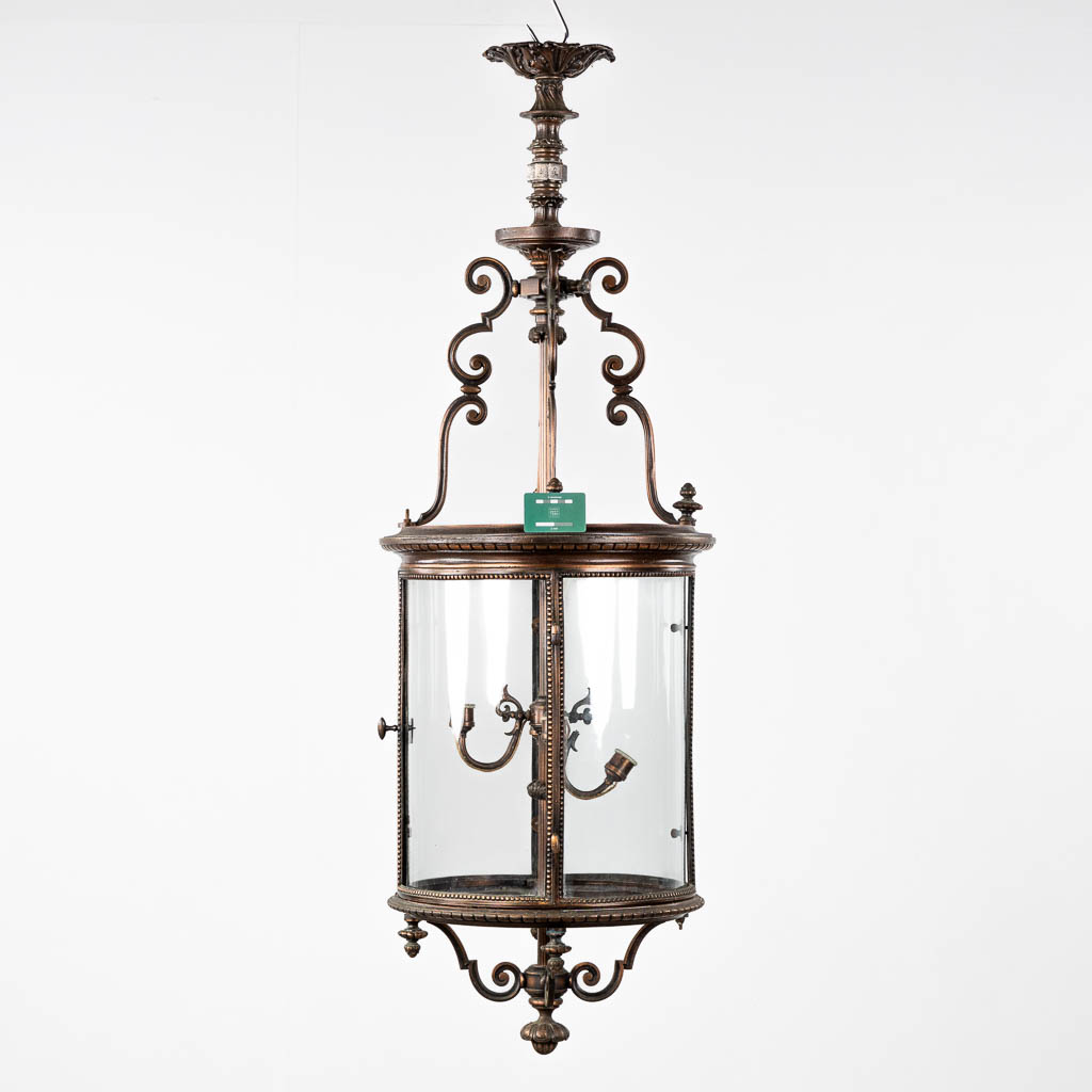 A large lantern, patinated metal and glass. Circa 1900. (H:144 x D:45 cm)