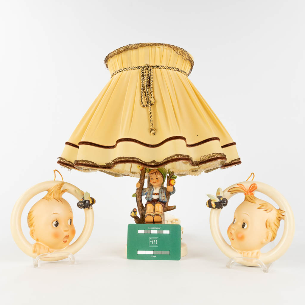 Hummel, een tafellamp en twee gezichtjes. (H: 26 cm)