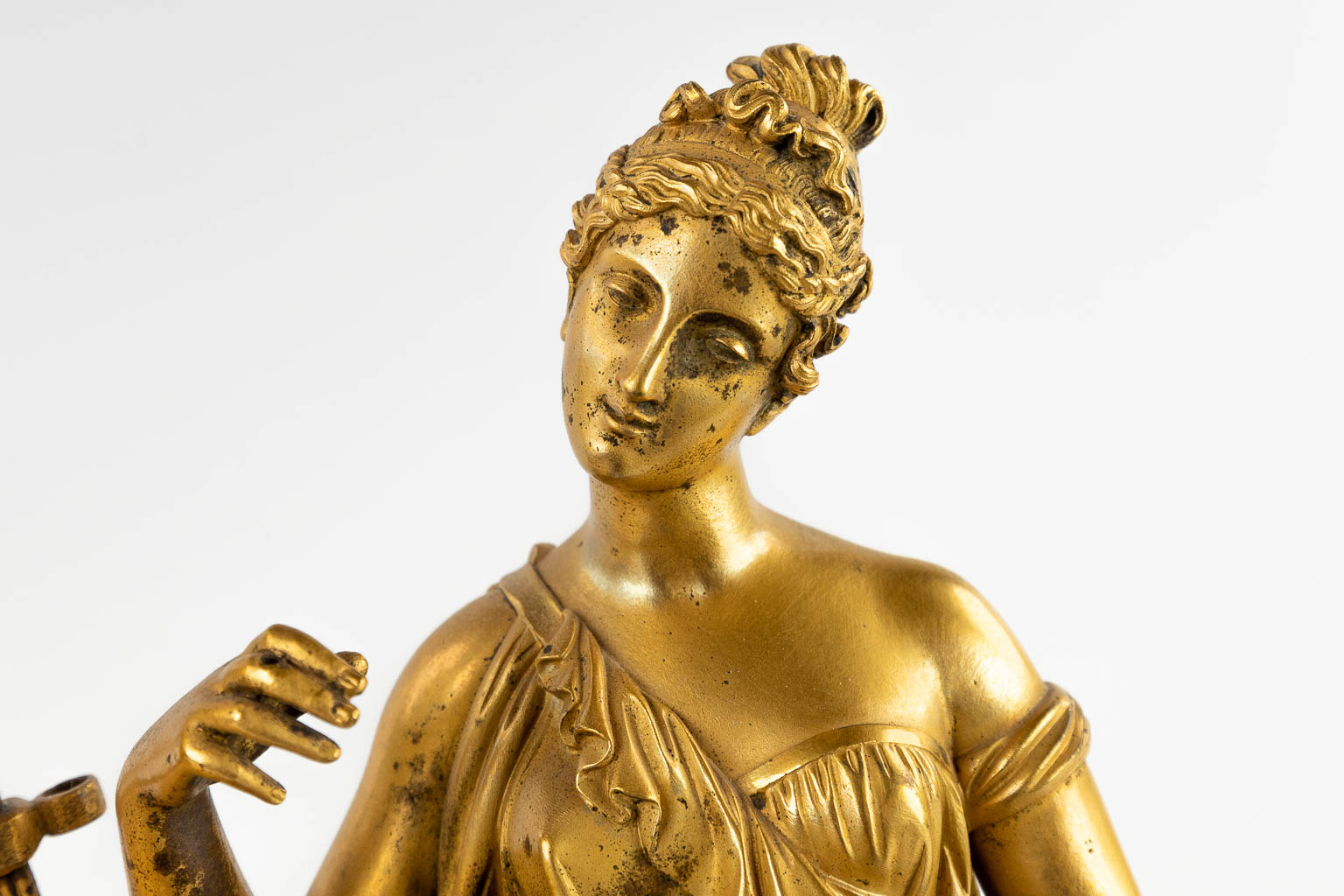 Een schouwklok met figuur van een galante dame, vuurverguld brons, Empire, 19de eeuw. (D:13 x W:32,5 x H:44 cm)