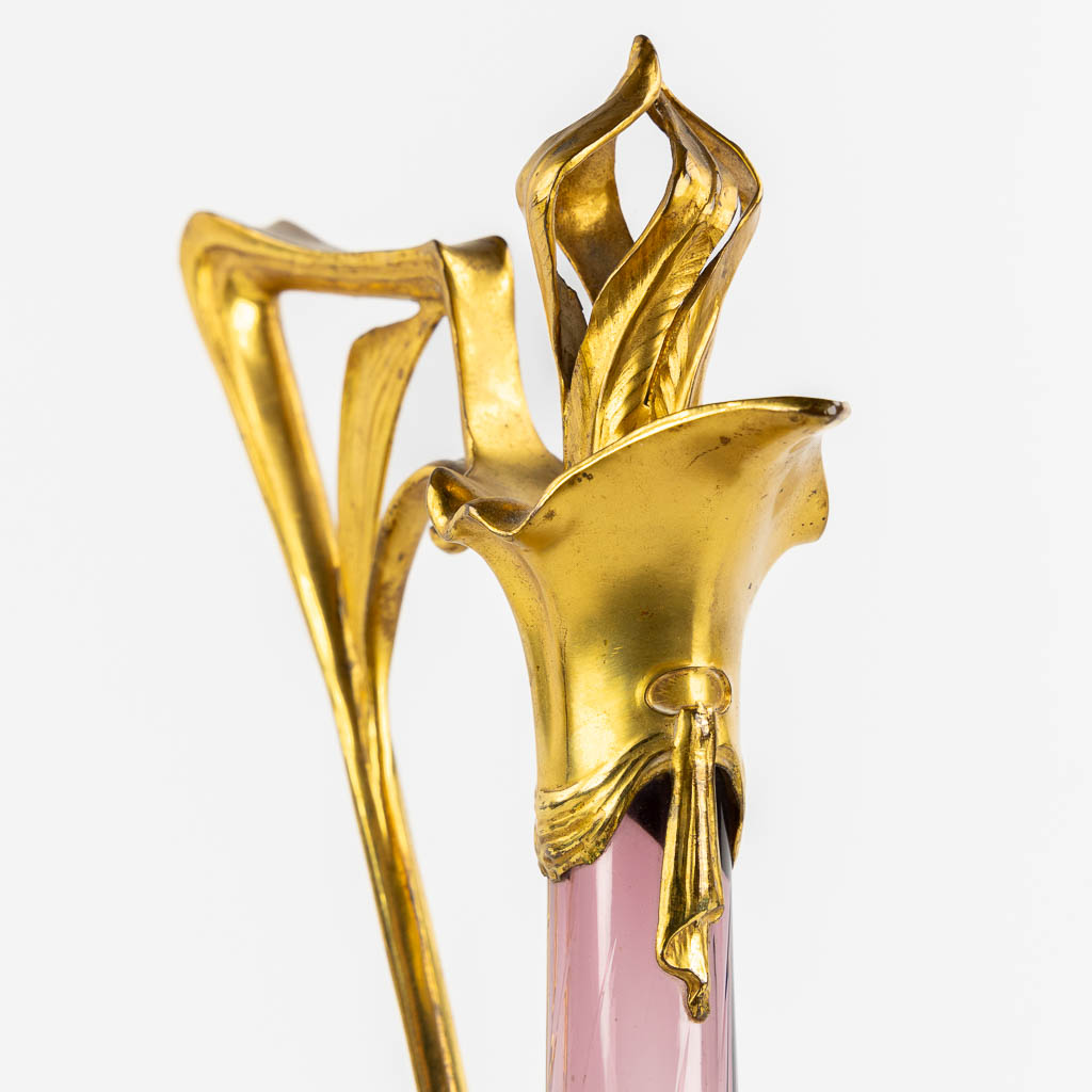A pitcher, gilt metal and purple glass, Art Nouveau. (L:16 x W:20 x H:39 cm)