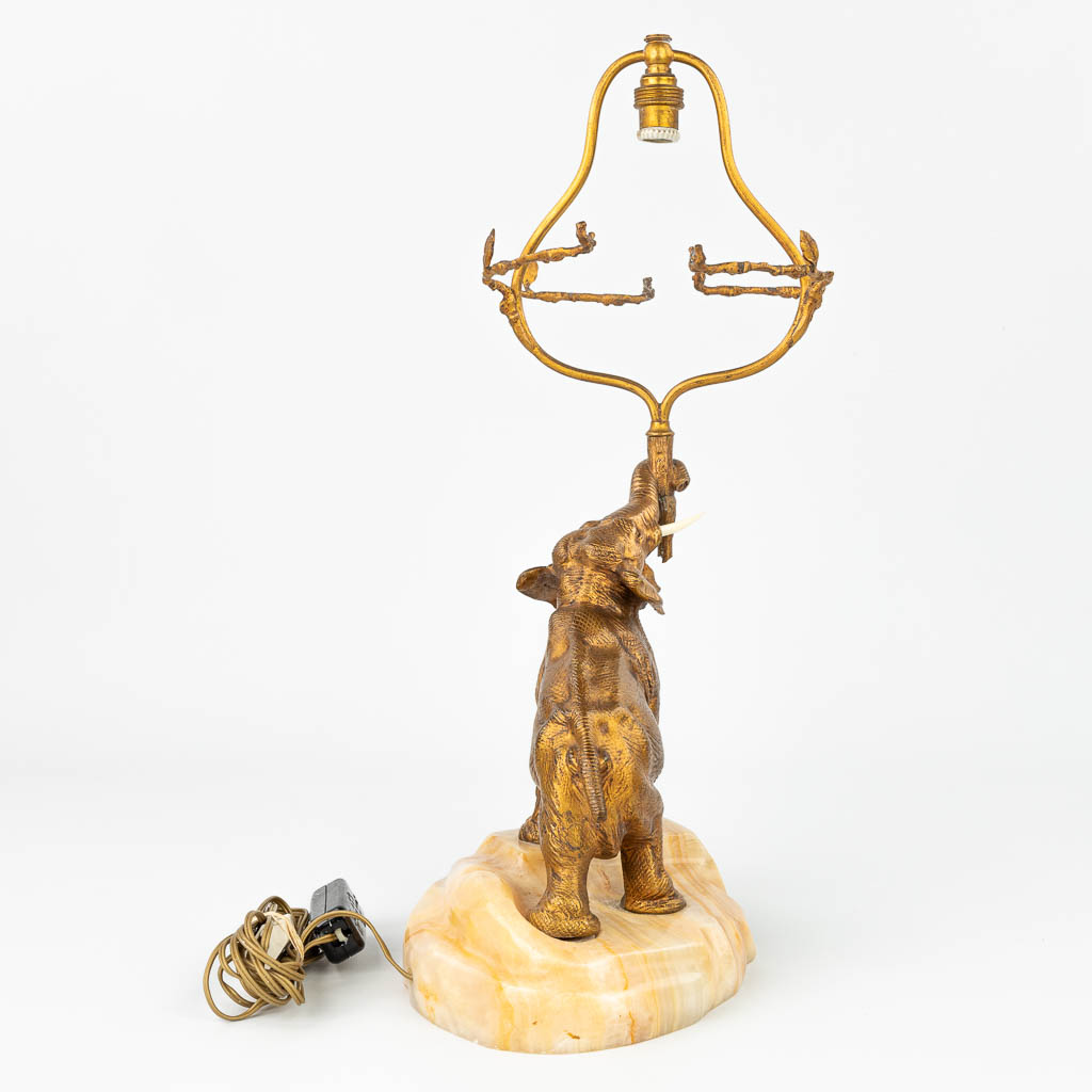 A table lamp 'Elephant figurine' made of gilt bronze with tusks, mounted on an onyx base and singed R. St. Yves. (H:46