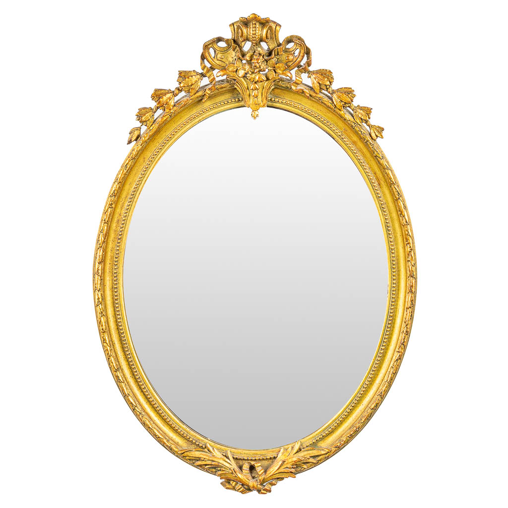 An antique and oval mirror in Louis XVI style