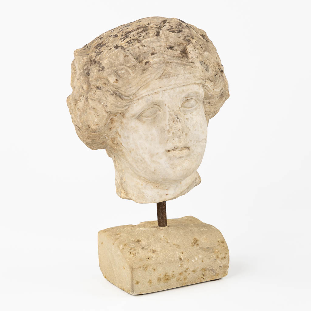 An antique sculptured marble head of a lady, mounted on a base. Probably of Roman origin. (L:25 x W:24 x H:26 cm)