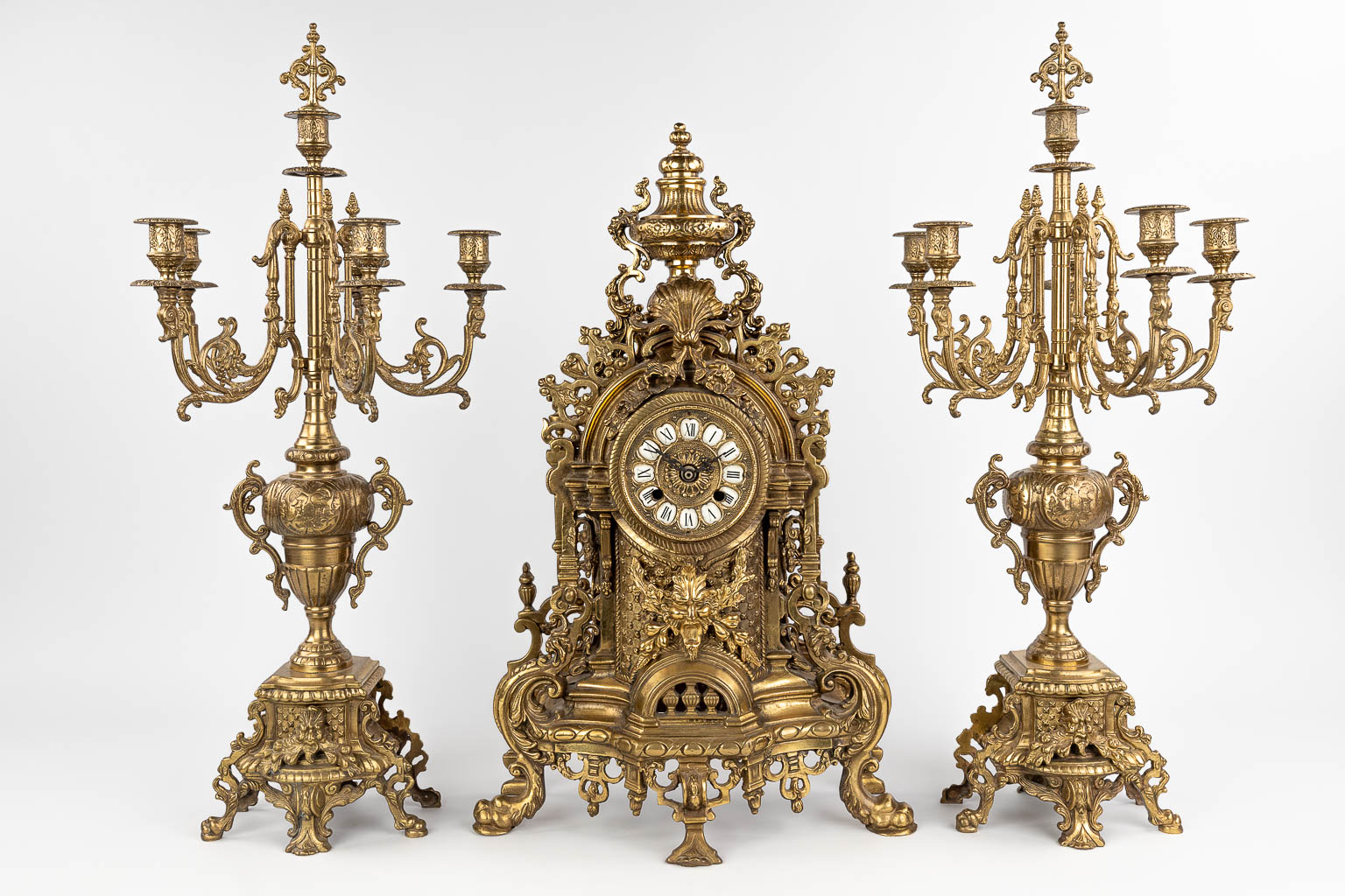 A three-piece mantle garniture consisting of a clock with candelabra, made of bronze. circa 1970. (W: 36 x H: 60 cm)