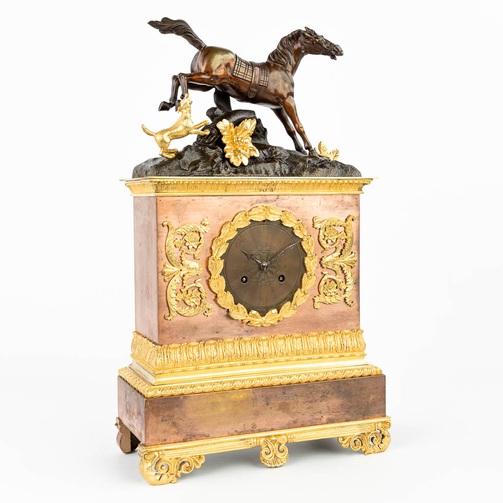 A mantle clock made of bronze and decorated with a horse and dog, empire style. (H:48cm)