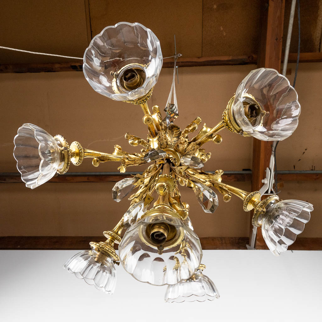 Een luchter, brons en geslepen kristal met 7 lichtpunten. Circa 1900. (H:46 x D:57 cm)