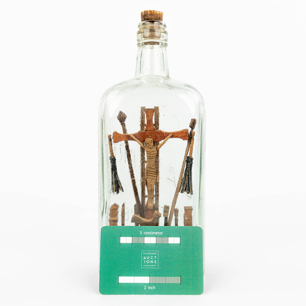 A Corpus Christi and crucifix mounted in a glass bottle. (H:24cm)