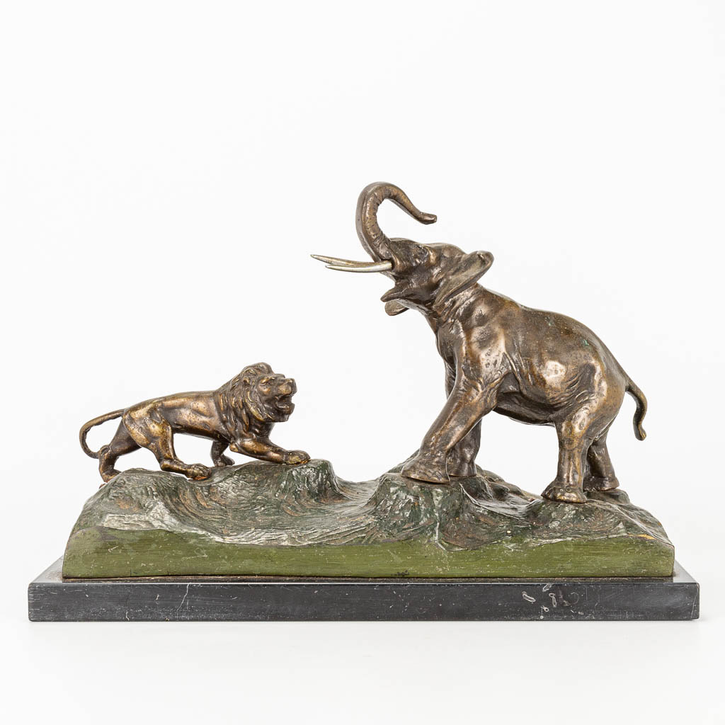 Een bronzen beeld van een olifant en leeuw, staande op een marmer basis