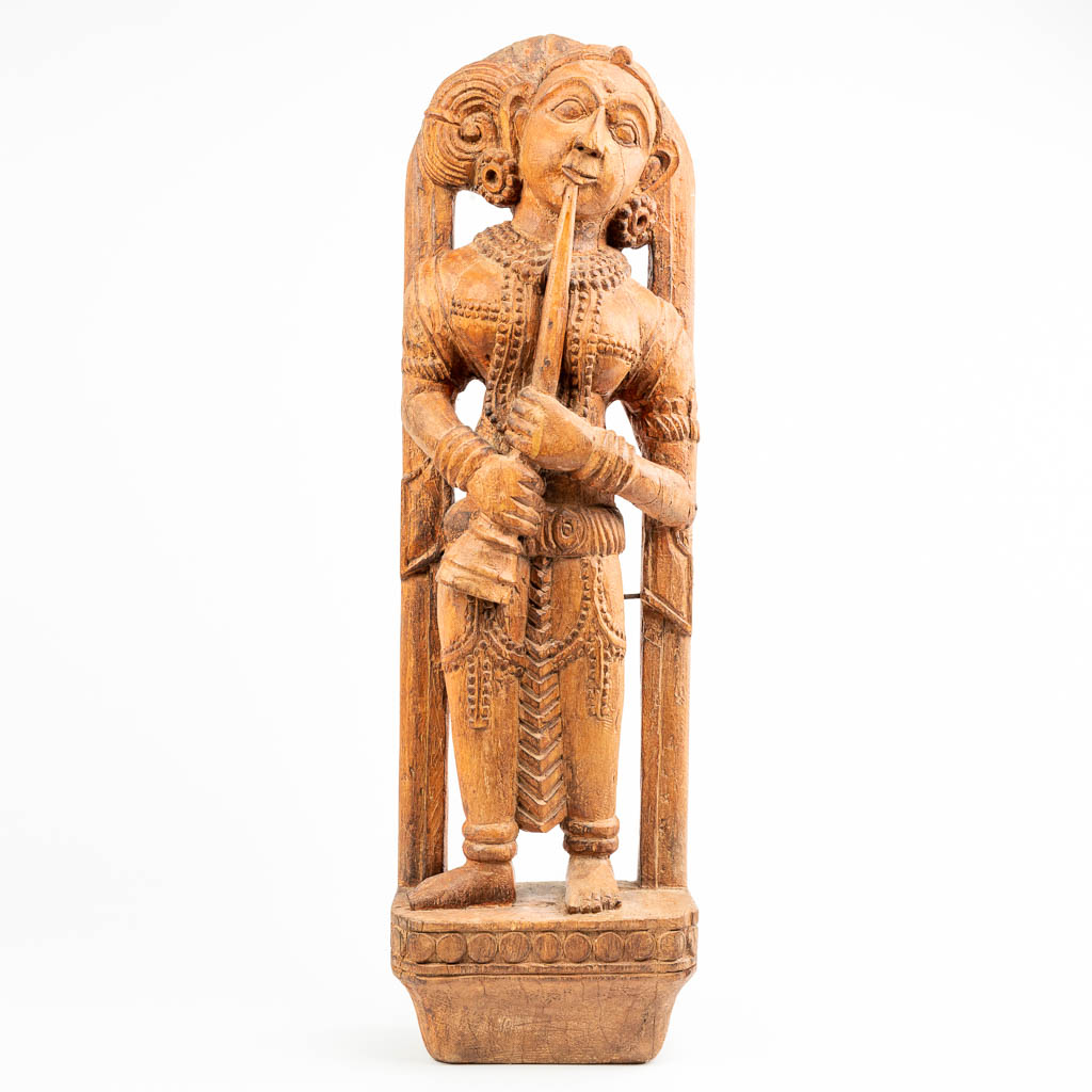 A statue made of sculptured hardwood, probably made in Indonesia. 