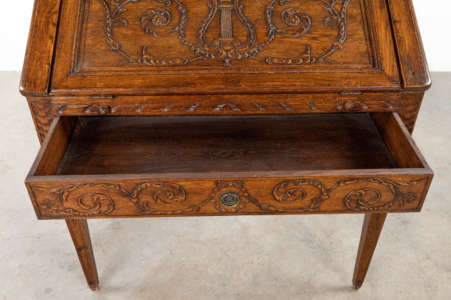 A secretaire made of sculptured wood in Louis XVI style, of oak. (H:92cm)