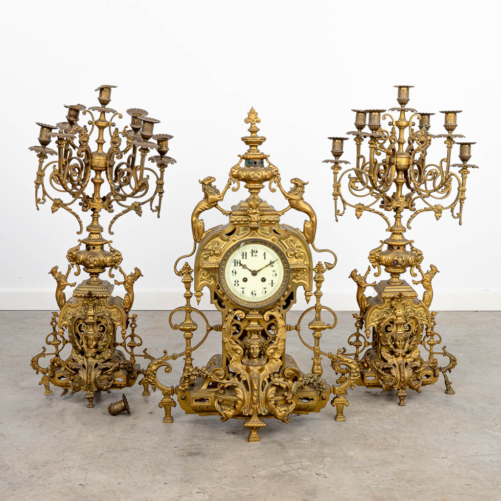 A three-piece mantle clock made of a bronze clock with candelabra. (H:70cm)