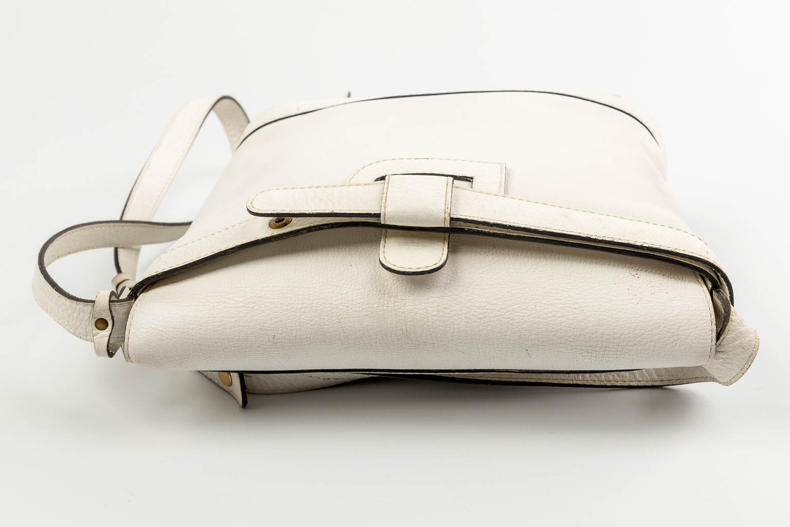 A purse made of white leather and marked Delvaux. 