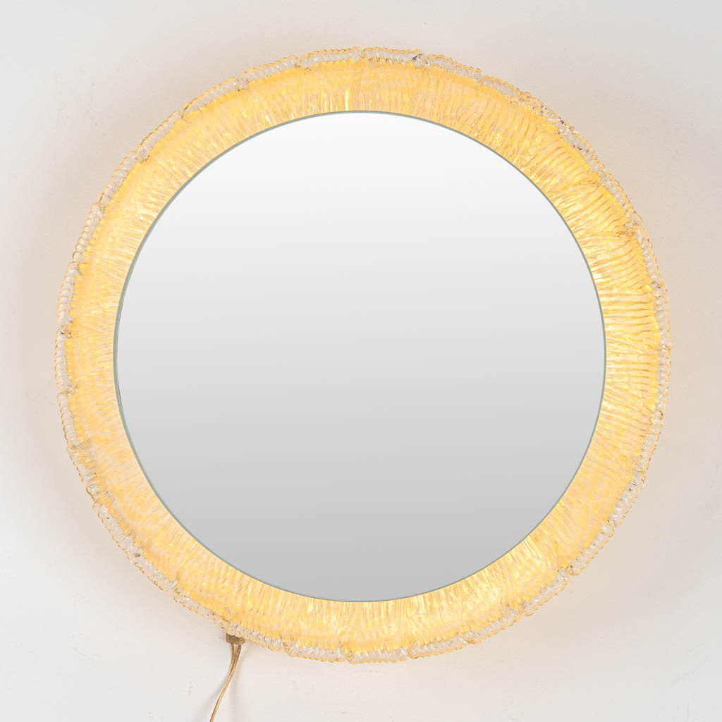 Een ronde spiegel met verlichting, acryl en glas, gemaakt door Deknudt. 