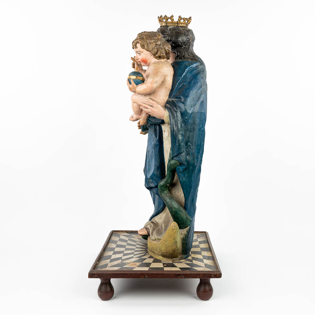 A patinated wood statue of Madonna with a child, standing on the serpent and half-moon. (H: 90 cm)