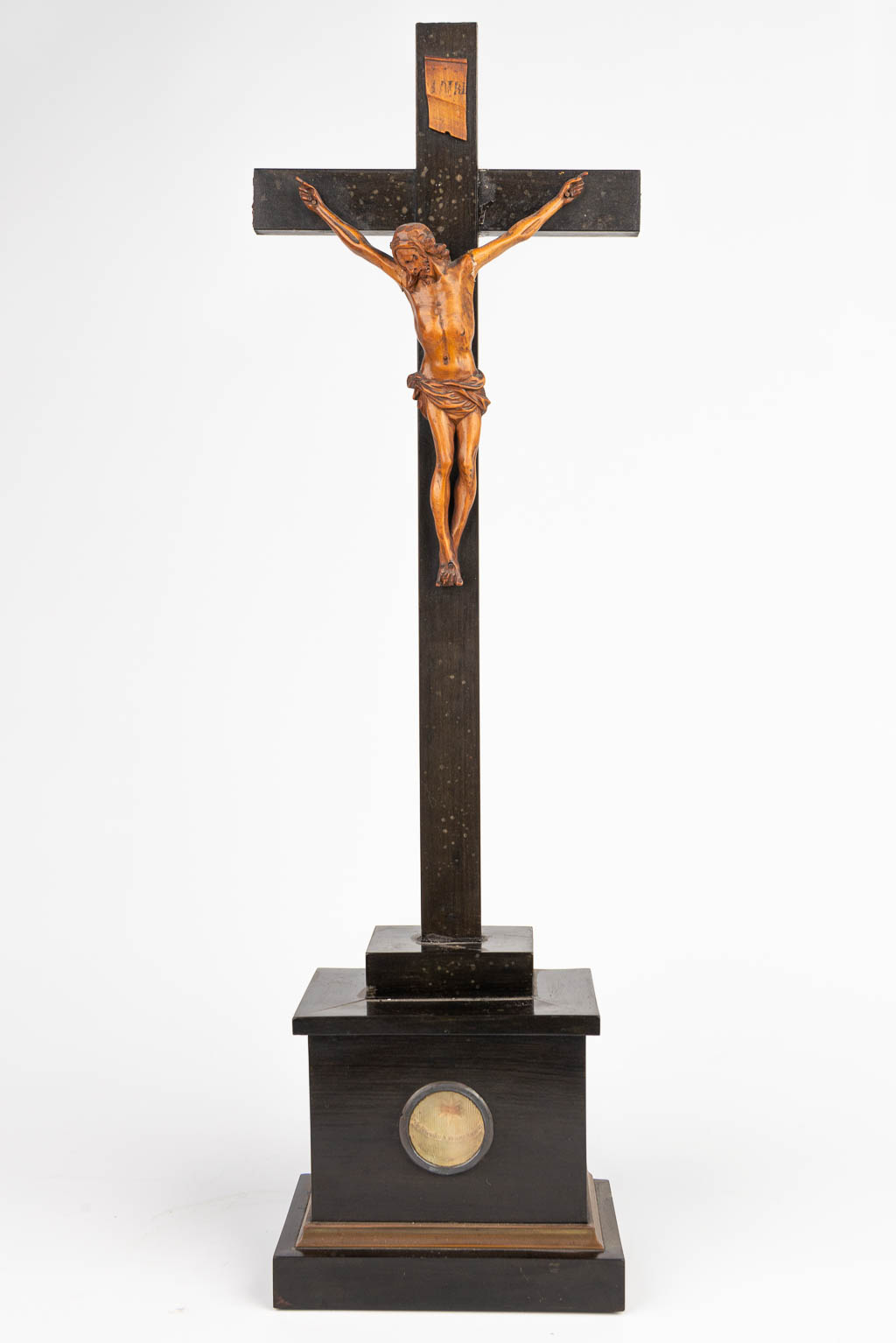 A sculptured Corpus Christi made of palm wood on an ebonised crucifix with a relic from 'Francis Xavier'. (H:51cm)