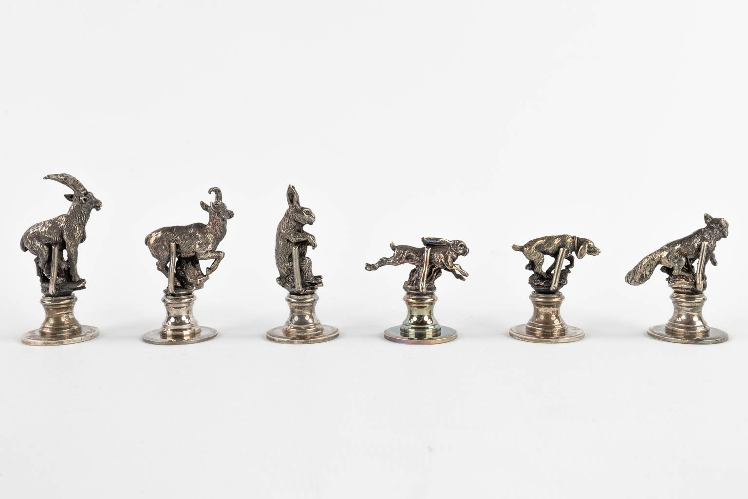 12 figuratieve zitplaats of menukaart houders, verzilverd brons. (H:5 cm)