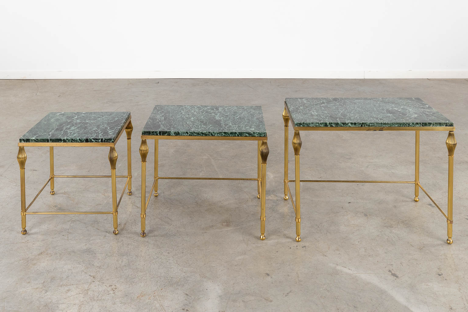 A three-piece set of nesting tables, gilt metal and a green marble. (D:37 x W:56 x H:45 cm)