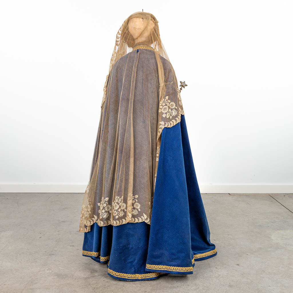 A procession madonna with robes, real hair and made of sculptured wood. 19th century. 