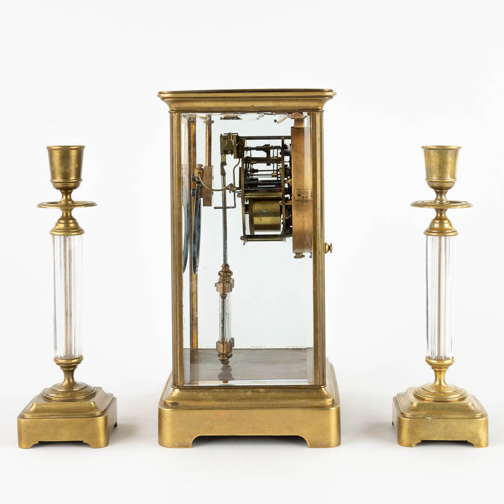 Een driedelige schouwgarnituur, klok met kandelaars. 19de eeuw. (D:14 x W:15 x H:26 cm)
