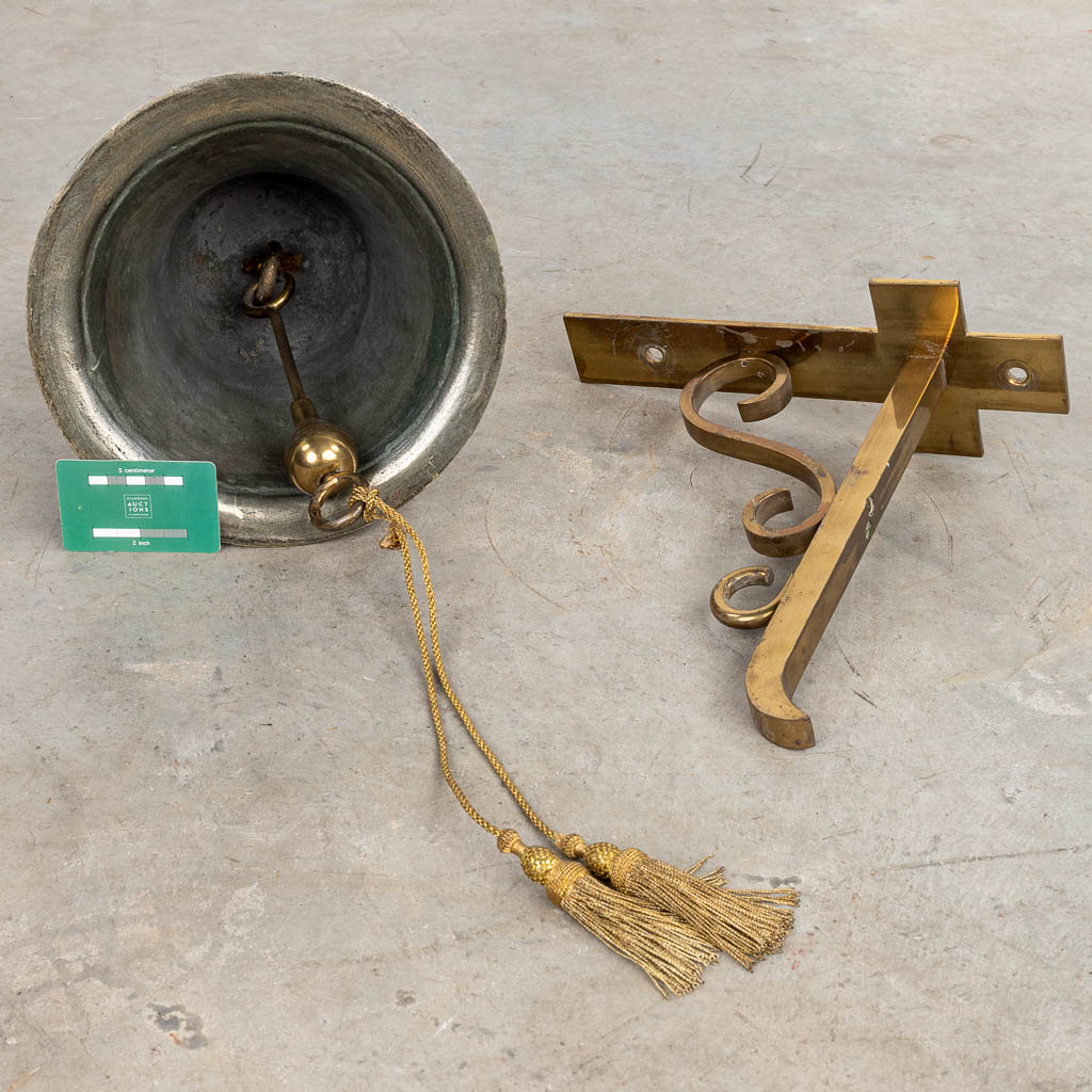 Een bronzen klok gemonteerd op een hangbeugel. (H:30cm)